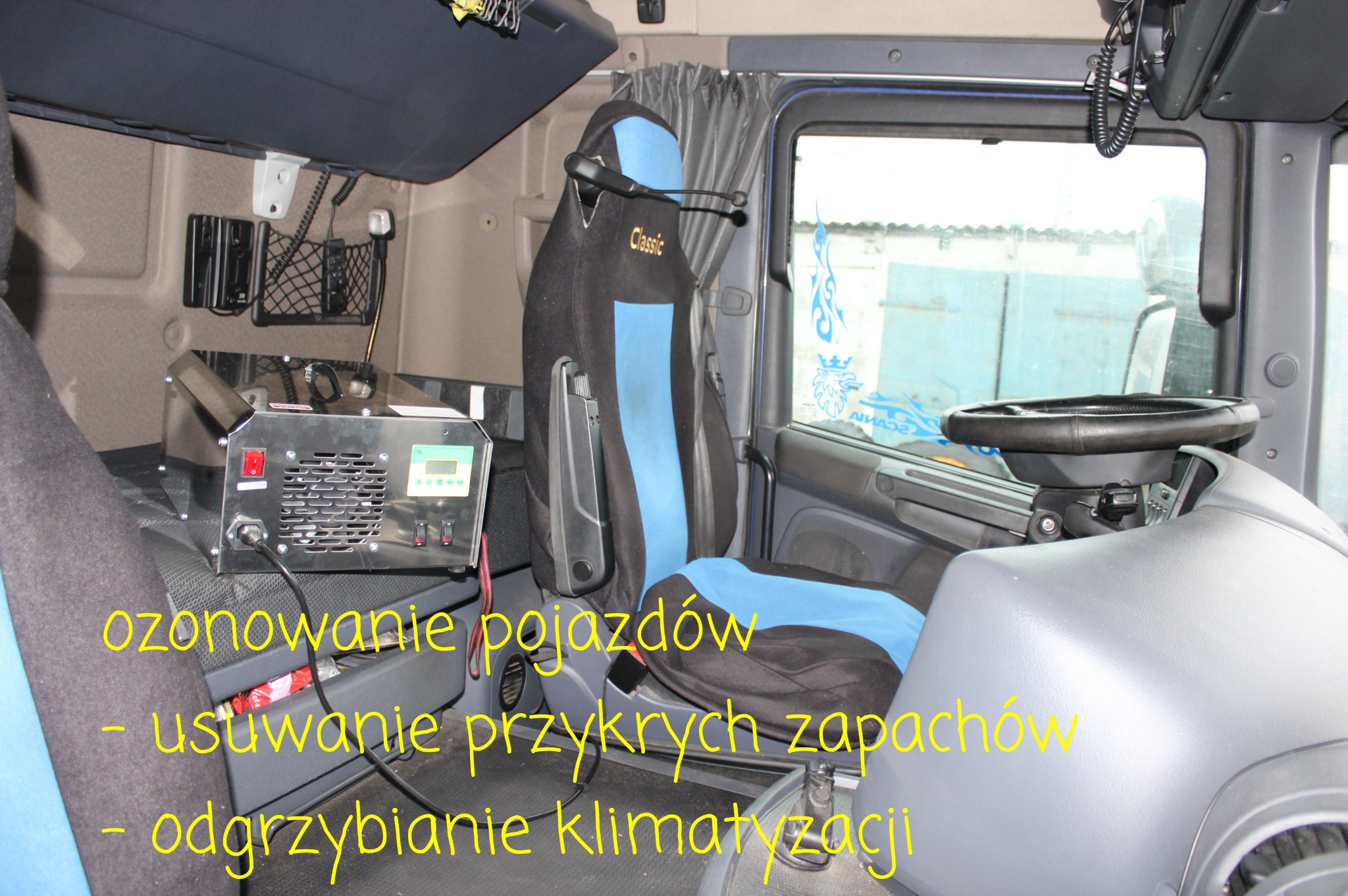 Wnętrze kabiny ciężarówki z widocznym urządzeniem do ozonowania, umieszczonym obok fotela kierowcy z napisem Classic, z widocznym panelem sterowania i przewodami.