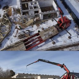 Przedsiębiorstwo Handlowo Usługowe Krzysztof Piekarski - Montaż więźby dachowej na surowym budynku z betonu komórkowego, z użyciem czerwonego dźwigu samochodowego na tle zimowego krajobrazu.