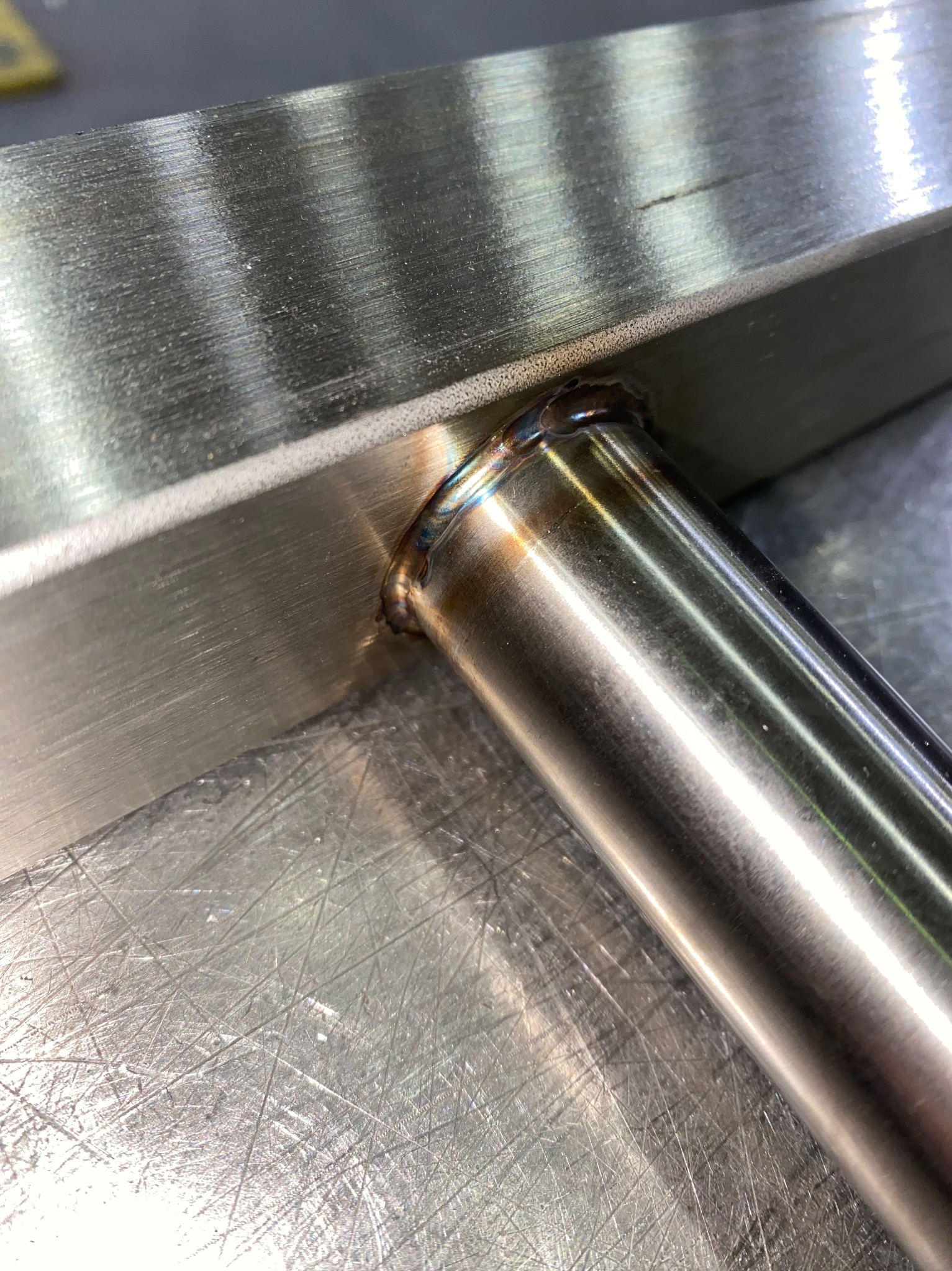 Precyzyjne spawanie rury ze stalowym profilem. Widoczne ślady po spawaniu i obróbce metalu. Detal złącza wykonany z dbałością o szczegóły.