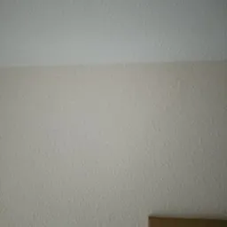 Tekstura ściany i sufitu po nałożeniu gładzi w Starachowicach, dolny róg kadru pokazuje fragment ramy lustra.