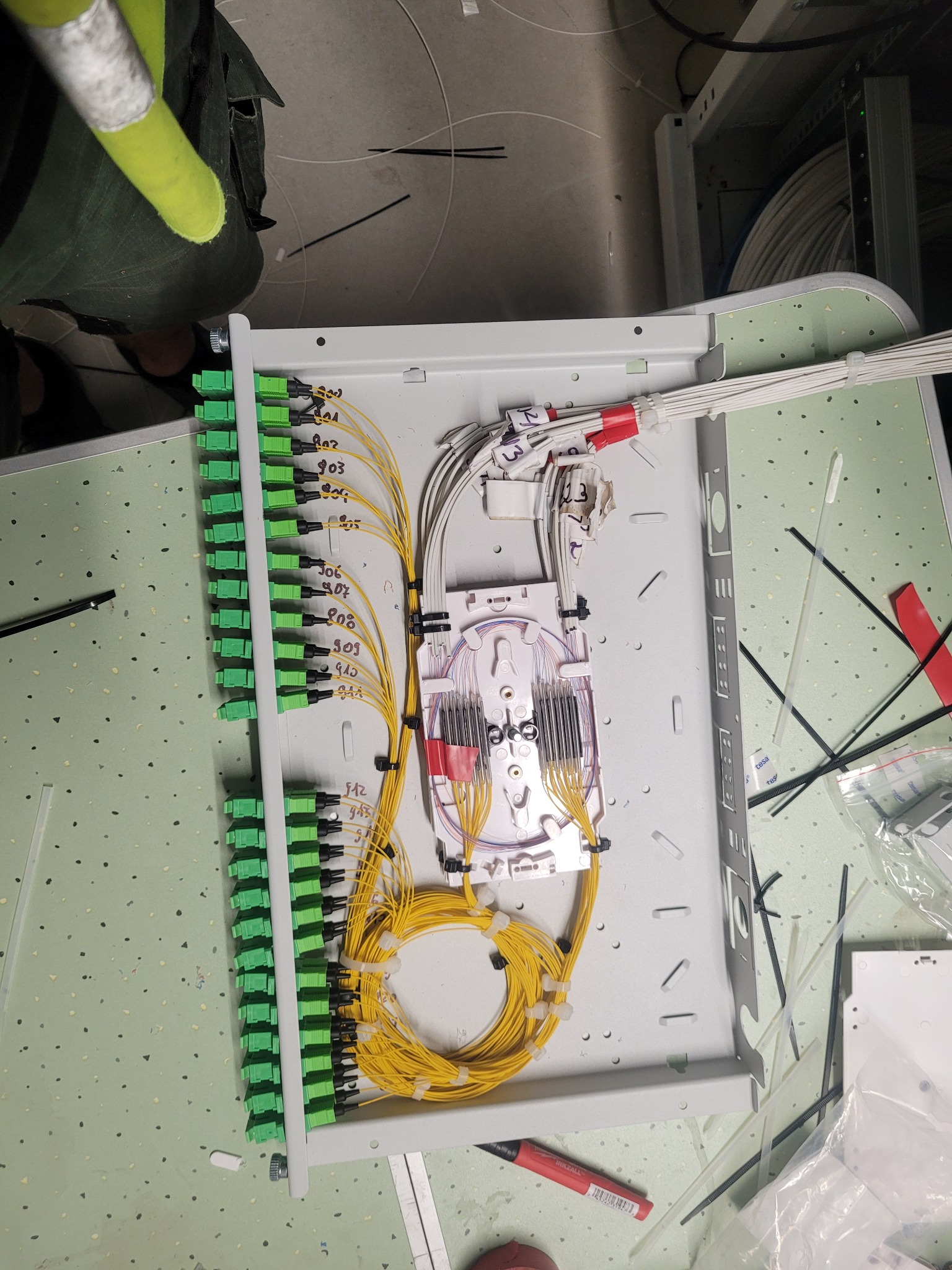 Rozdzielnica światłowodowa z precyzyjnie ułożonymi kablami w Wawrzeńczycach. Widoczne złącza i oznaczenia, świadczące o profesjonalnym montażu.