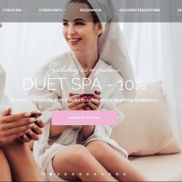 BGLAM sp. z o.o. - Dwie uśmiechnięte kobiety w białych szlafrokach i ręcznikach na głowach siedzą na huśtawce, prezentacja oferty Duet Spa -10% na stronie internetowej salonu kosmetycznego.