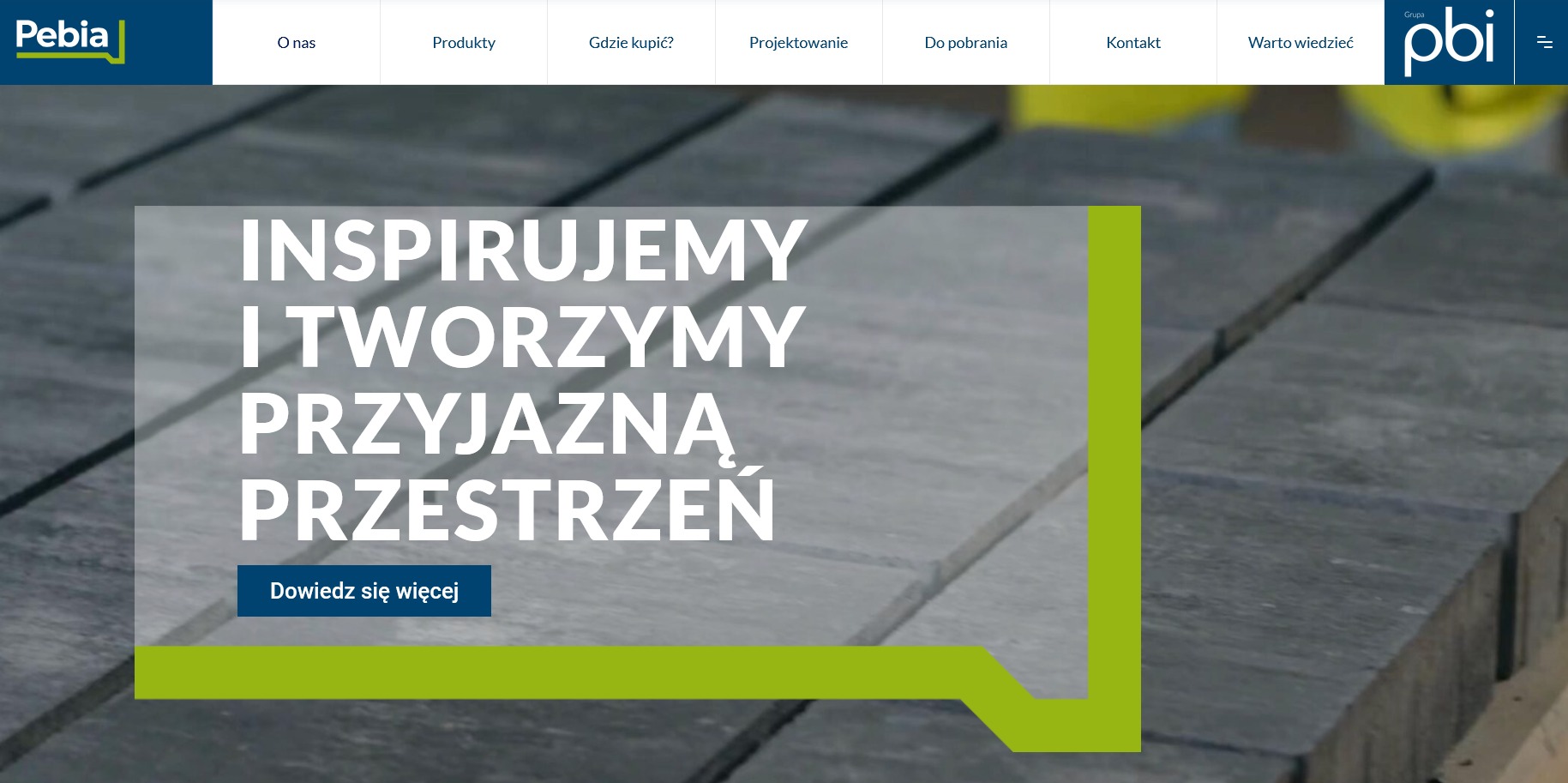 Strona internetowa producenta kostki brukowej z hasłem 'Inspirujemy i tworzymy przyjazną przestrzeń' na tle ułożonej kostki.