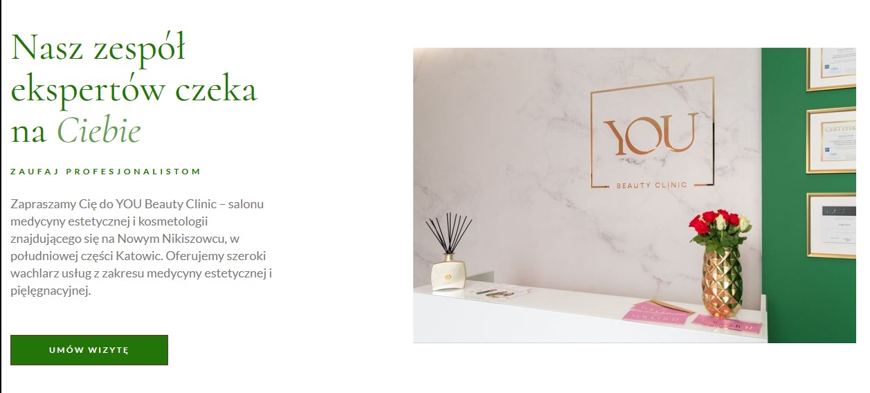 Recepcja salonu YOU Beauty Clinic z logo na marmurowej ścianie, wazonem z czerwonymi i białymi różami oraz certyfikatami na zielonej ścianie po prawej stronie.
