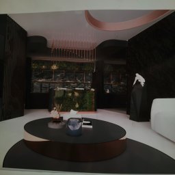 Perfect Wall - Wizualizacja wnętrza z ciemnymi marmurowymi ścianami, roślinnością w tle, okrągłym stolikiem kawowym z dekoracjami i rzeźbą.