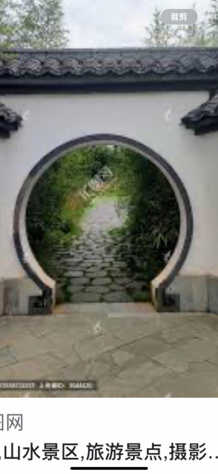 Okrągłe przejście w murze, ukazujące ścieżkę z kamieni w ogrodzie z bujną roślinnością.