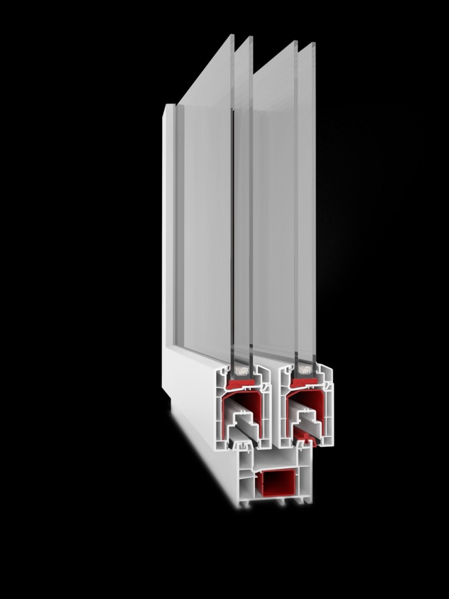 Przekrój okna PCV z trzema szybami, widoczne profile białe i czerwone uszczelki, na czarnym tle.