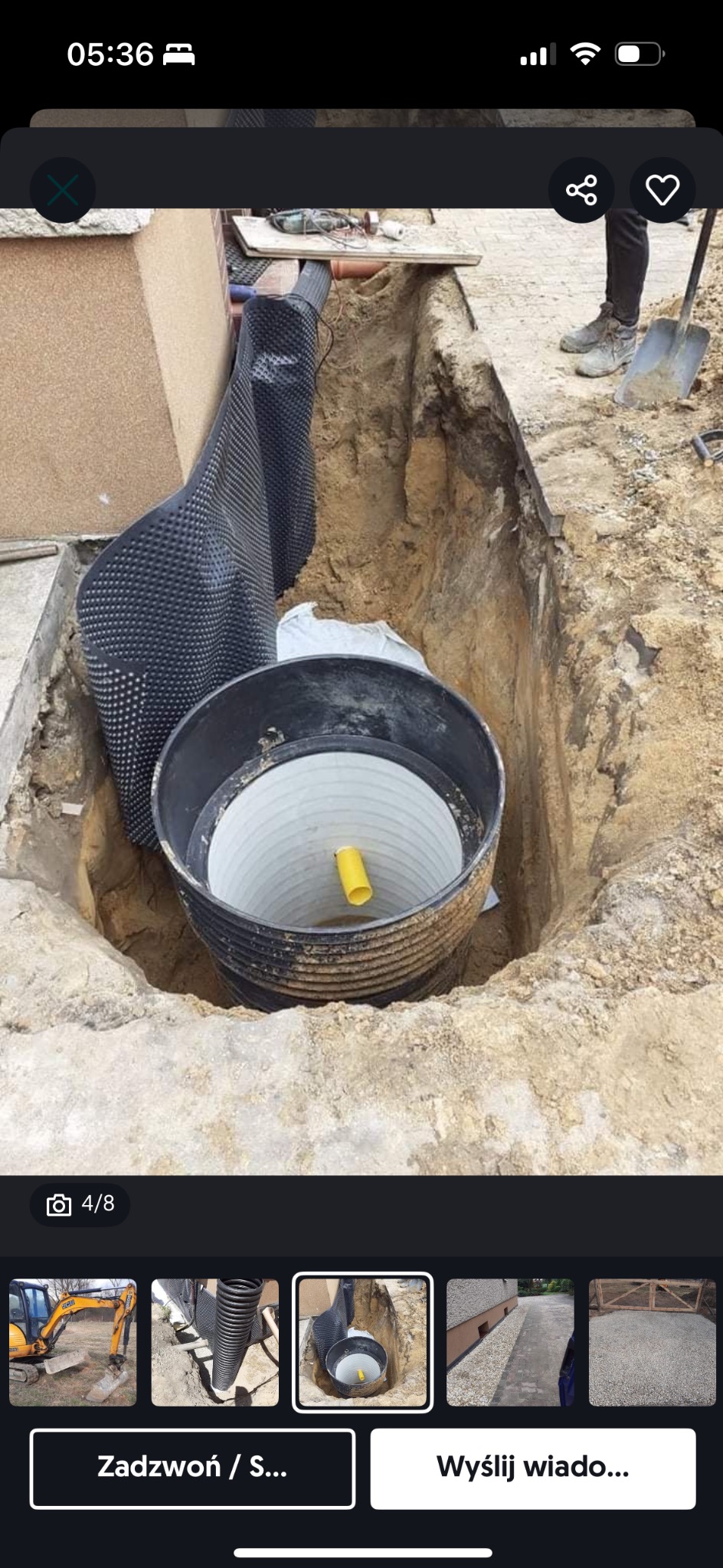 Wykopany dół z wstawionym zbiornikiem z tworzywa, zabezpieczony folią kubełkową, widoczna rura wewnątrz zbiornika, obok leży łopata
