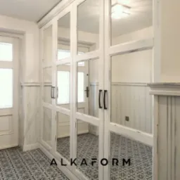 Biała szafa wnękowa z lustrami, widoczne postarzane wykończenie drewna i wzorzysta podłoga w korytarzu.