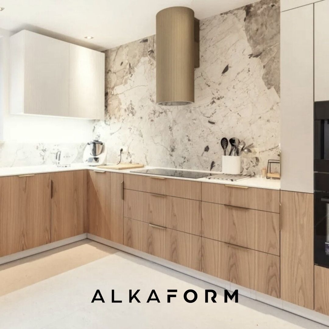 Nowoczesna kuchnia z drewnianymi frontami, marmurowym backsplashiem i okrągłym, złotym okapem, minimalistyczne uchwyty, jasne oświetlenie.