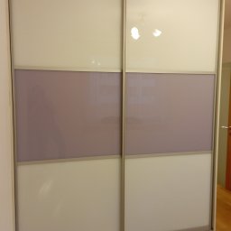 Szafa z drzwiami przesuwnymi firmy Raumplus z szybą lacobel 