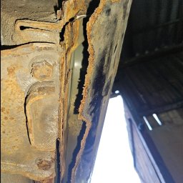 Jakub Pakulski - Silnie skorodowany próg samochodu, widoczne liczne ogniska rdzy i ubytki metalu, sfotografowane od dołu z perspektywy osoby leżącej pod pojazdem.