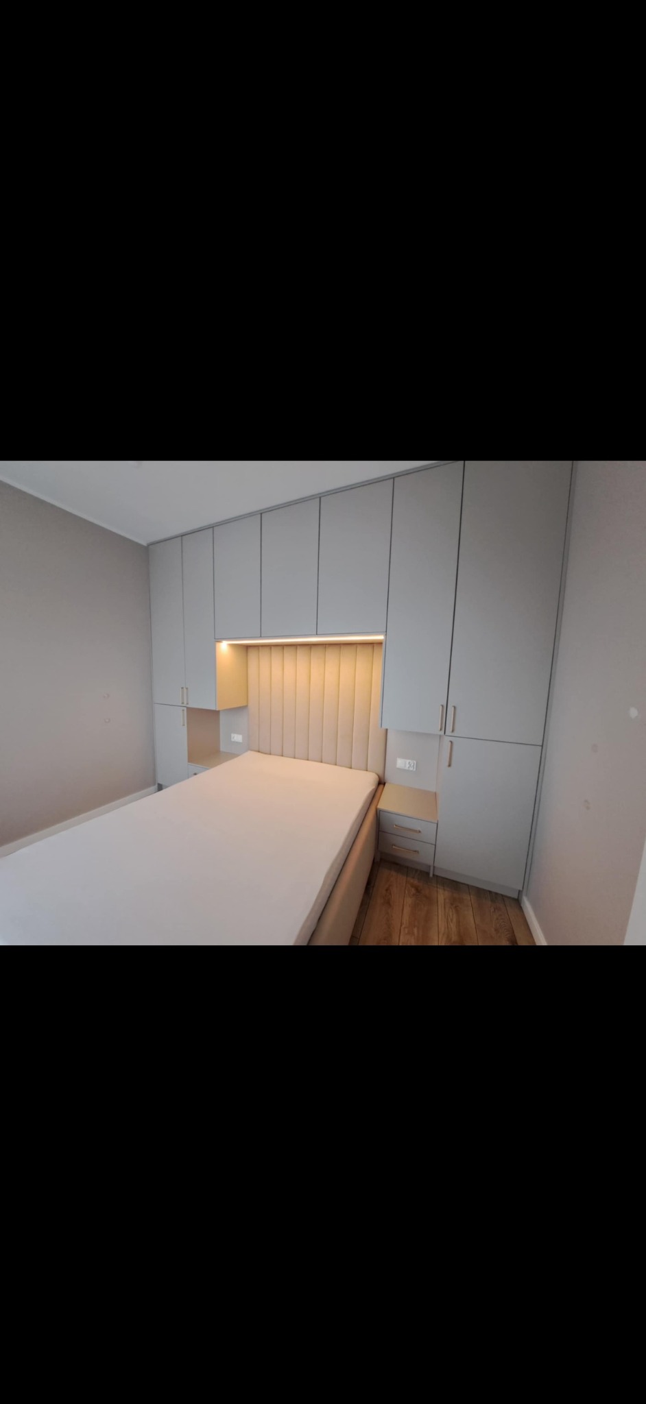 Zabodowa łóżka w kolorze kaszmiru z dodatkiem złotych uchwytów oraz ledami