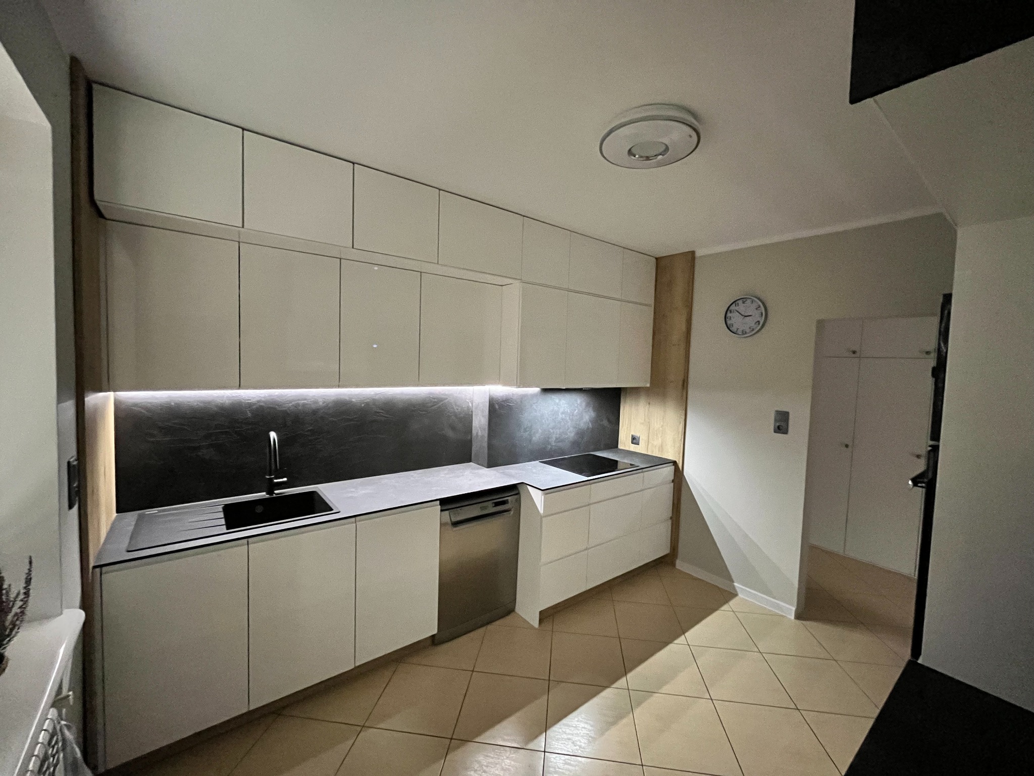 Piękna kuchnia w frontach w wysokim połysku raz blatem HPL z dodatkiem ledów w odcieniu zimnym