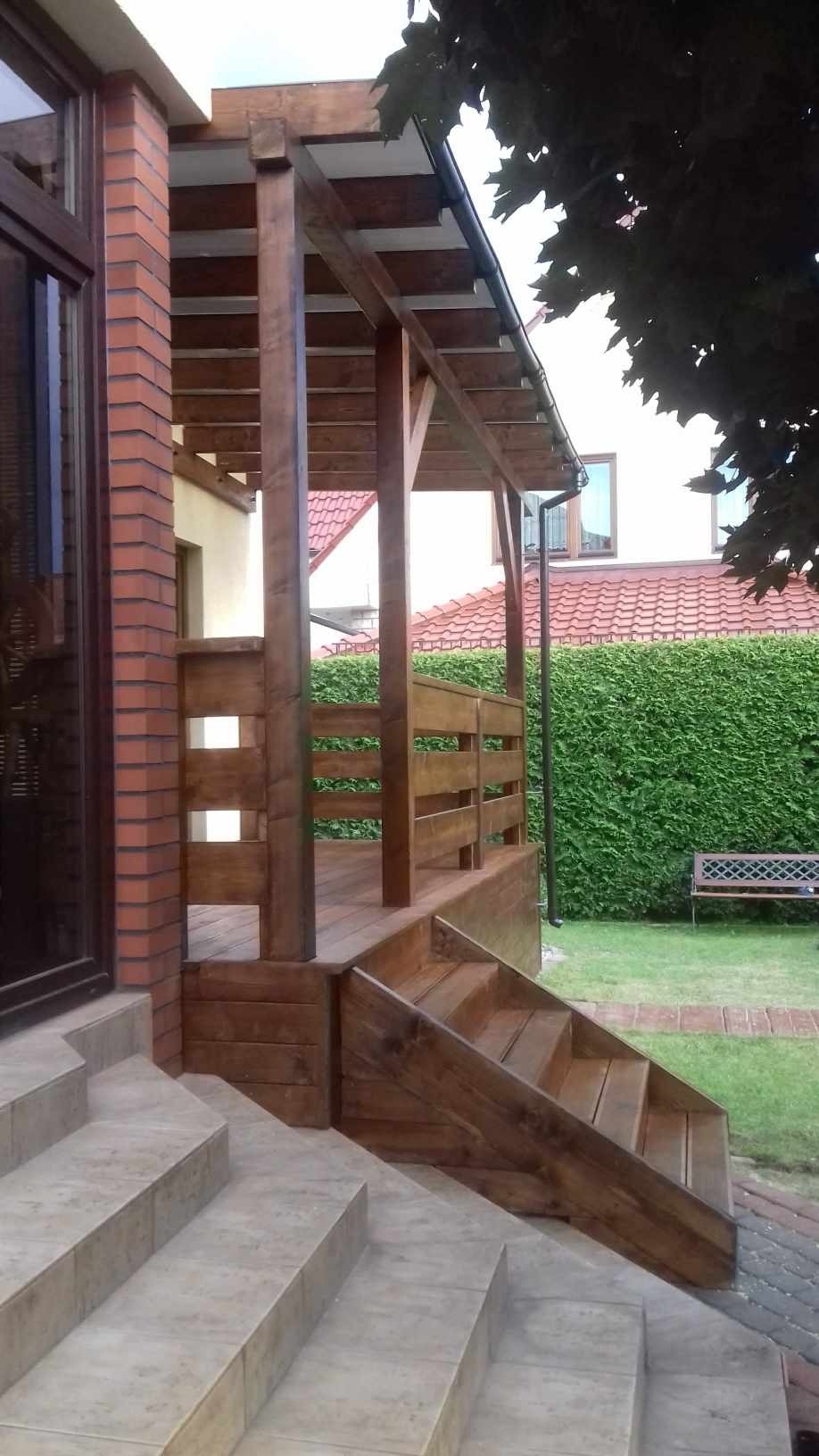 Drewniany taras z zadaszeniem, wykonany w Gdyni, z widocznymi schodami z płytek i elementami drewnianej balustrady.