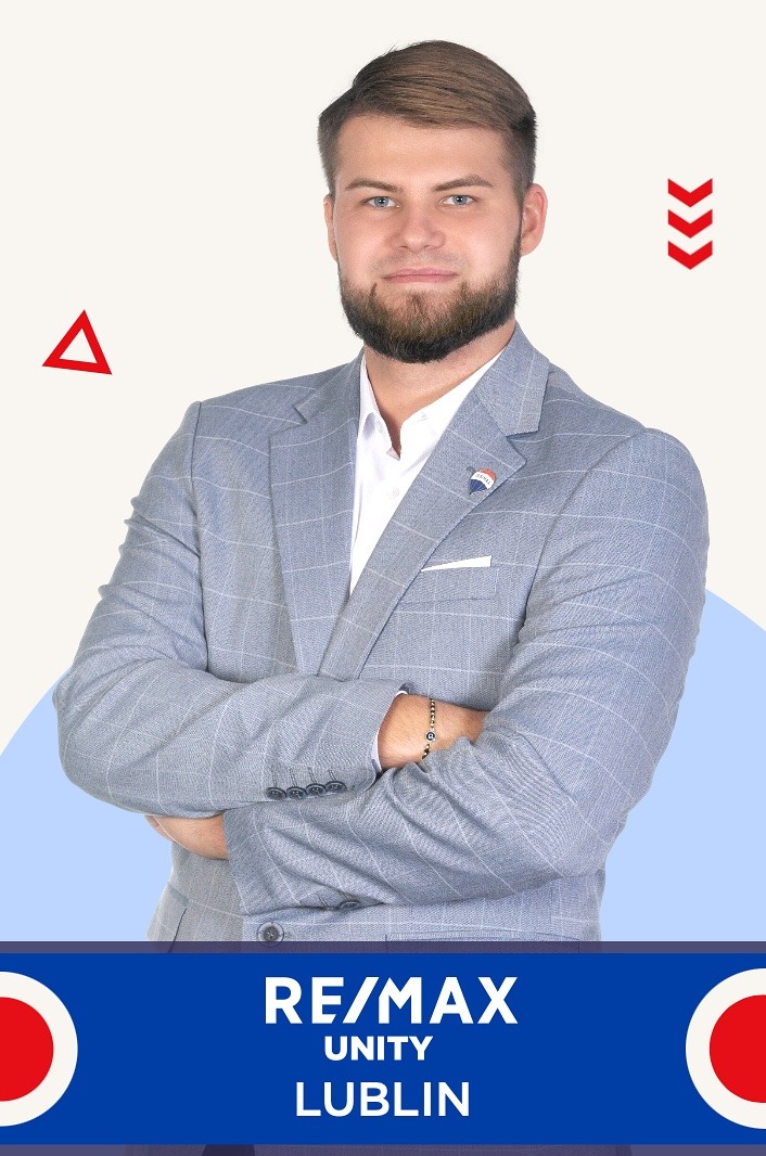 Portret mężczyzny w szarej marynarce z logo RE/MAX na klapie, na jasnym tle z elementami graficznymi i napisem RE/MAX Unity Lublin.