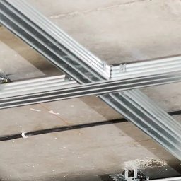 MichtMar - Metalowa konstrukcja sufitu podwieszanego zamocowana do surowego stropu, widoczne profile i elementy montażowe.