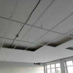 Zakład Ogólnobudowlany Michał łakomy - Montaż sufitu podwieszanego kasetonowego z widocznymi elementami konstrukcyjnymi i instalacją elektryczną, kilka kasetonów brakuje.