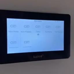 Panel sterowania systemem alarmowym Satel z włączoną opcją 'Garaż', wyświetlający status oświetlenia posesji.