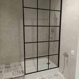 F.U.H ŁUKASZ SZUMSKI - Nowoczesna kabina prysznicowa z czarną ramą i wzorzystymi płytkami podłogowymi. Minimalistyczny design, szklane ścianki, chromowana armatura i jasne, neutralne kolory.