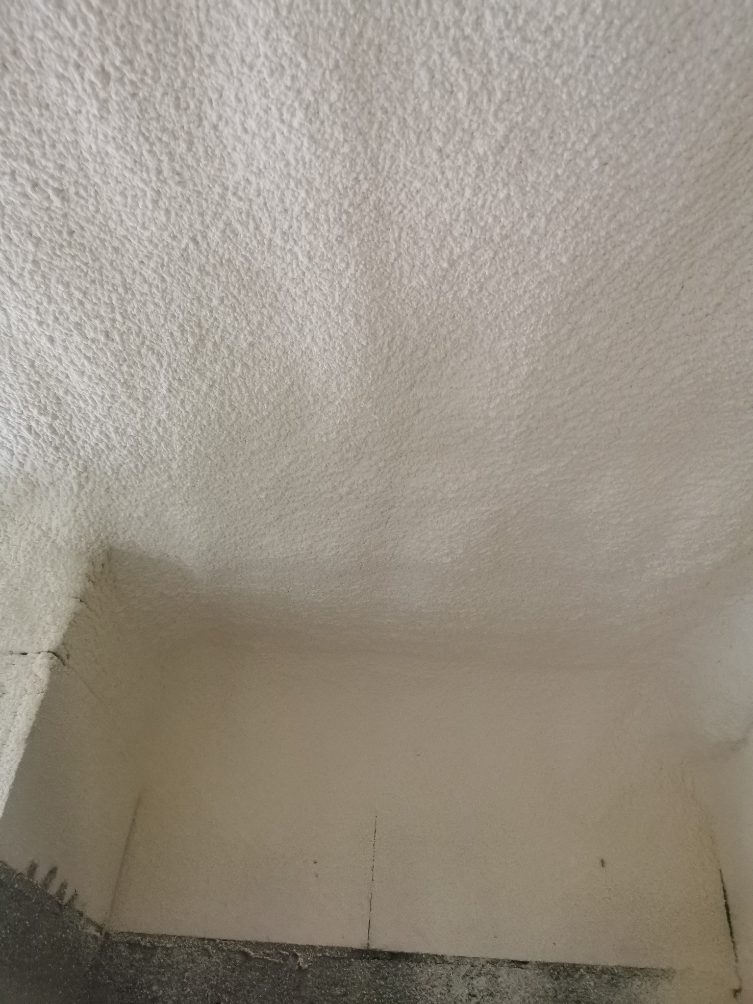 Poddasze po natrysku pianką PUR w Króliku Polskim. Widoczna struktura izolacji na ścianach i suficie, równomierne pokrycie. Detal wykończenia narożnika.