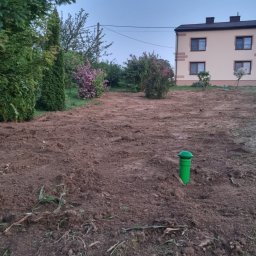 BIOLEN GRZEGORZ RYBIŃSKI - Przygotowany teren pod instalację z dwoma zielonymi odpowietrznikami, widoczny budynek mieszkalny w tle oraz częściowo usunięta warstwa ziemi.