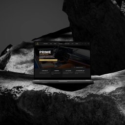 Ovocode - Laptop wyświetla stronę internetową firmy Auto Spa Lublin, umieszczony na tle abstrakcyjnej, ciemnej skały.