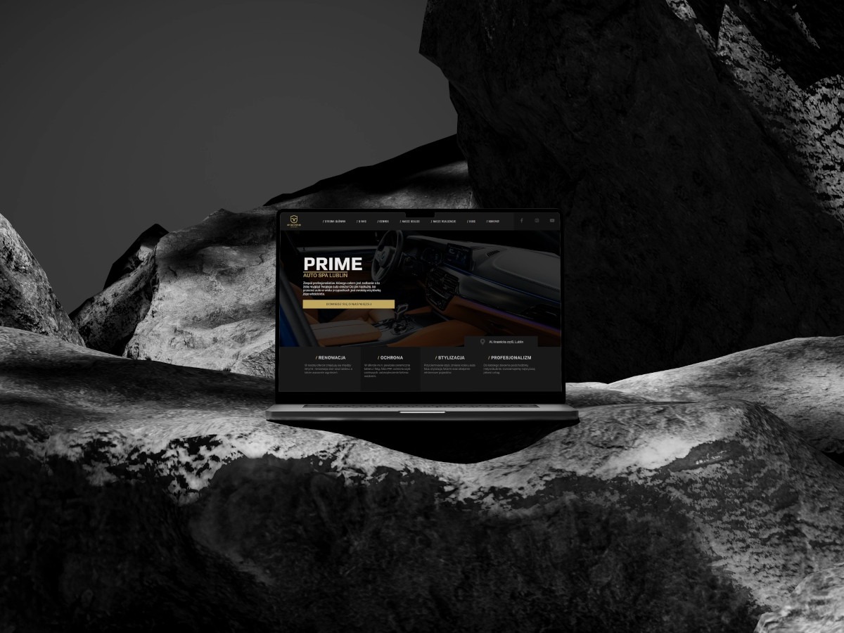 Laptop wyświetla stronę internetową firmy Auto Spa Lublin, umieszczony na tle abstrakcyjnej, ciemnej skały.