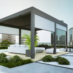 Nowoczesna pergola metalowa z roletami przeciwsłonecznymi na tarasie z widokiem na miasto, z drewnianą podłogą, białymi meblami ogrodowymi i roślinami ozdobnymi.