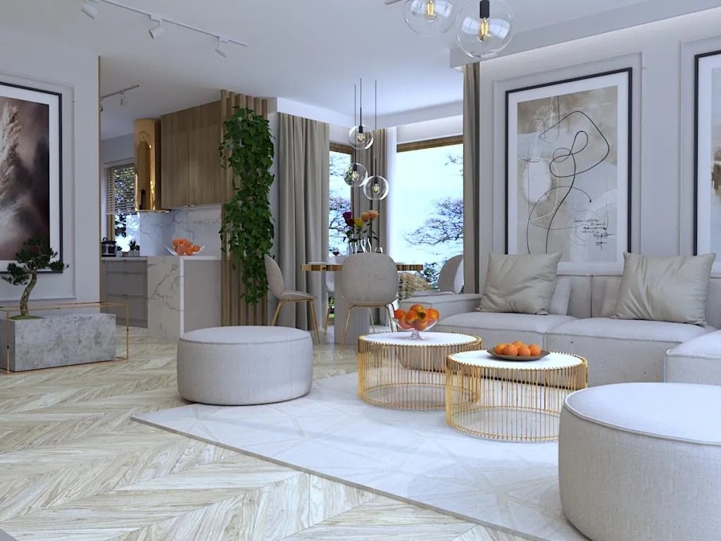 Jasne, przestronne wnętrze z parkietem w jodełkę, obejmujące salon z sofą, stolikami kawowymi z owocami, pufami i dekoracyjnymi obrazami na ścianach, przechodzące w otwartą kuchnię z marmurowym...