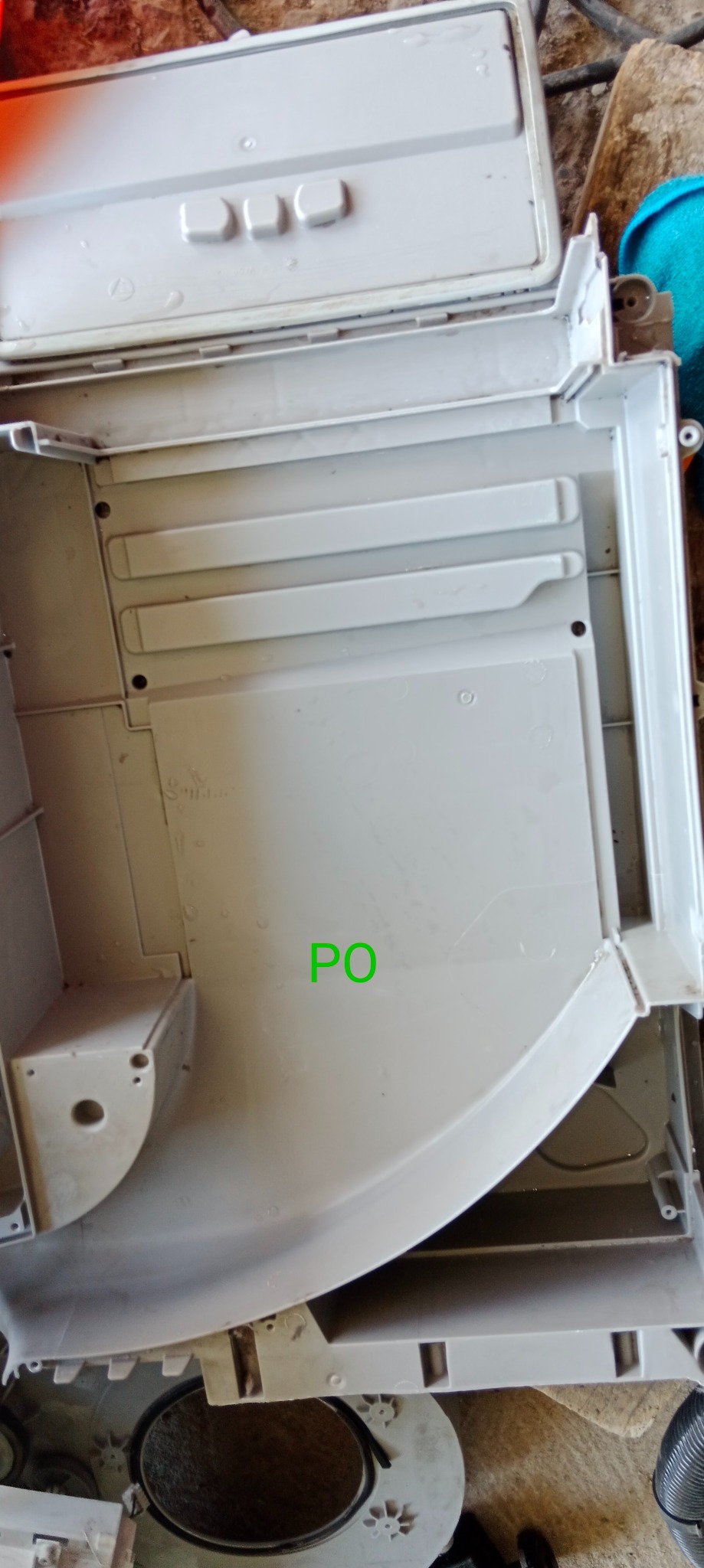 Wnętrze obudowy urządzenia AGD, prawdopodobnie zmywarki, ukazujące jej konstrukcję wewnętrzną i elementy montażowe. Widoczne detale obudowy.