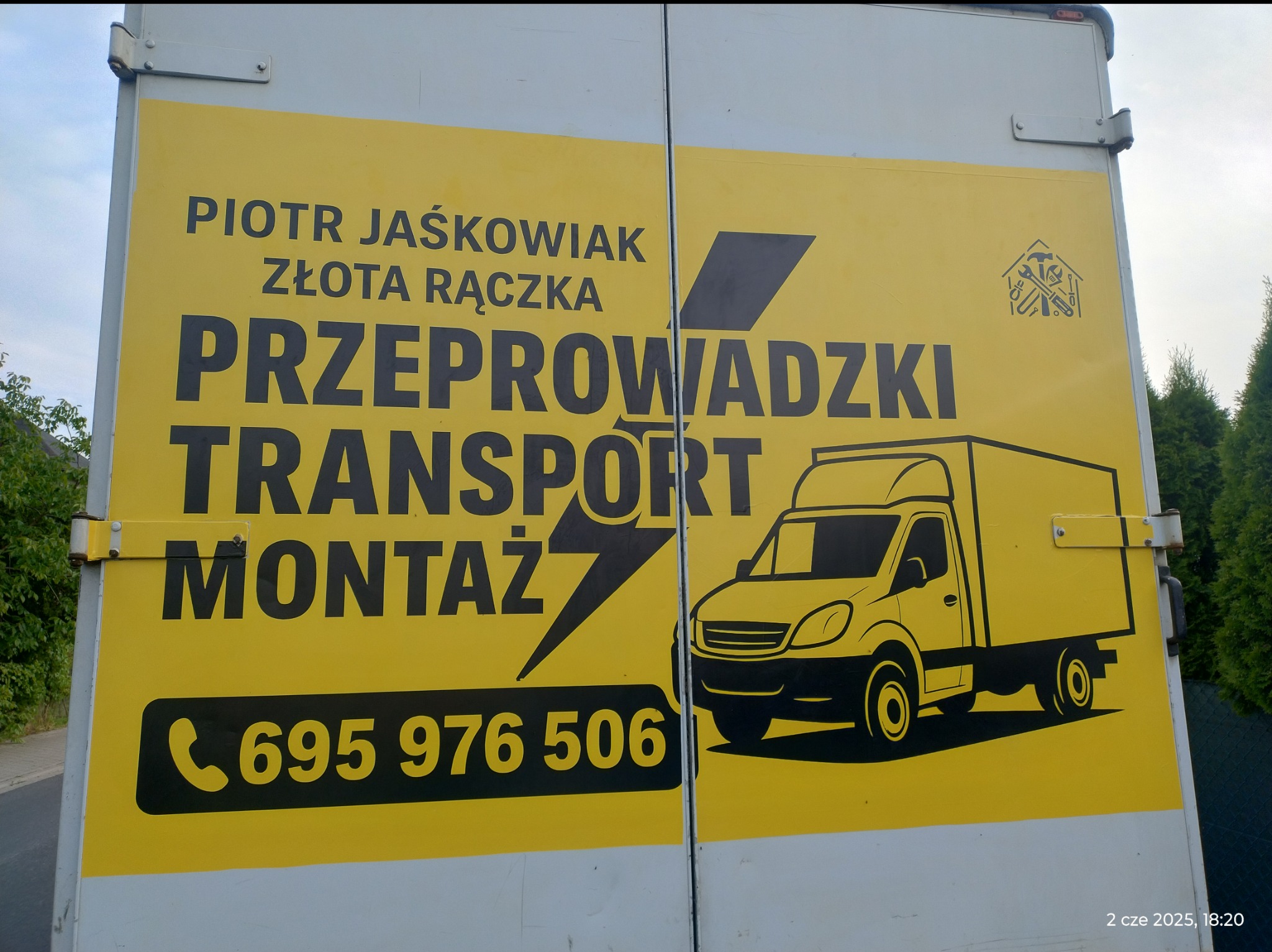 Żółte drzwi busa z czarnym nadrukiem: Przeprowadzki, Transport, Montaż. Grafika busa i numer telefonu. Nazwa firmy: Piotr Jaśkowiak Złota Rączka.