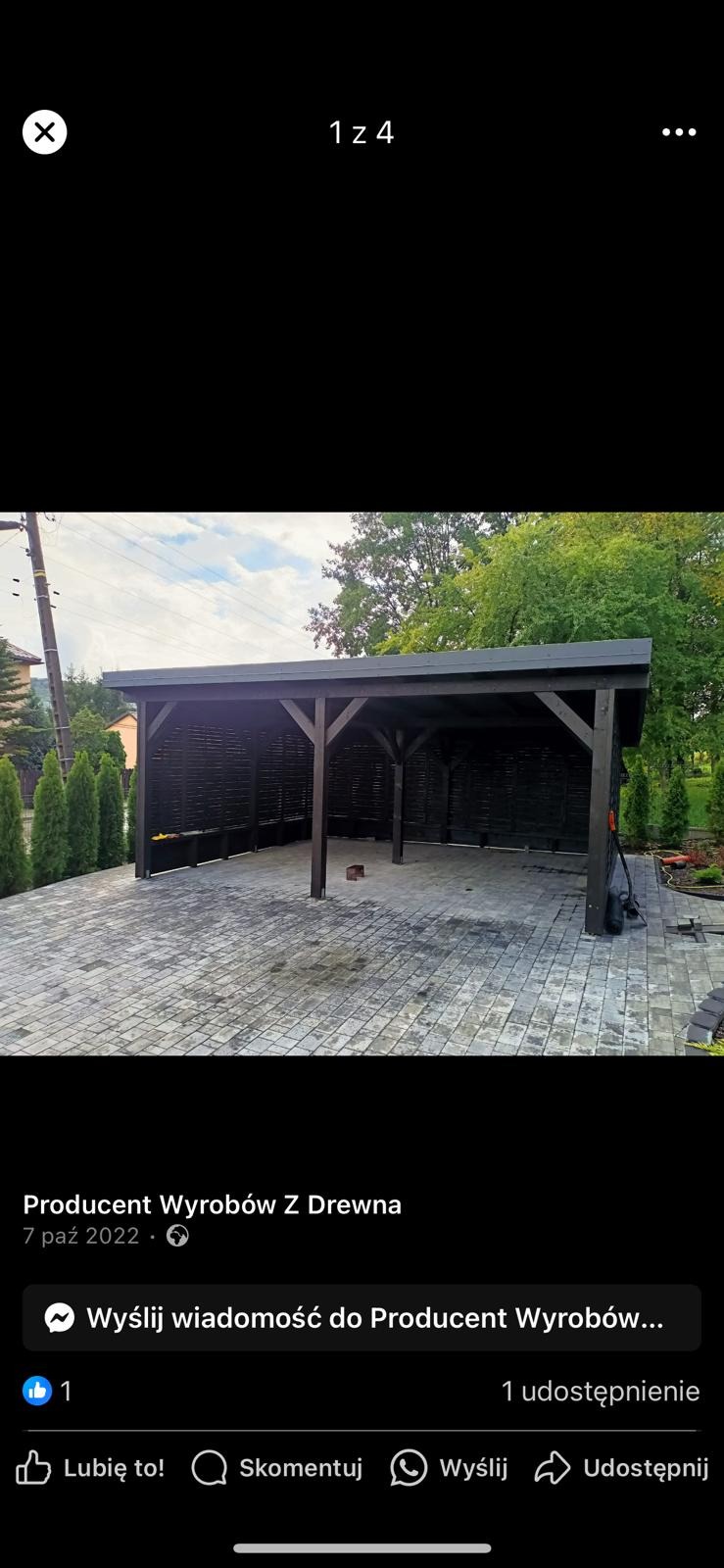 Ciemna, drewniana konstrukcja z ażurowymi ścianami w ogrodzie, z kostką brukową na podłożu i zielenią w tle.