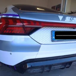 Tył oklejonego samochodu Audi E-Tron GT (ICE RACE) po kolizji, odtworzony wygląd fabryczny, widoczna tablica rejestracyjna i elementy graficzne okleiny.