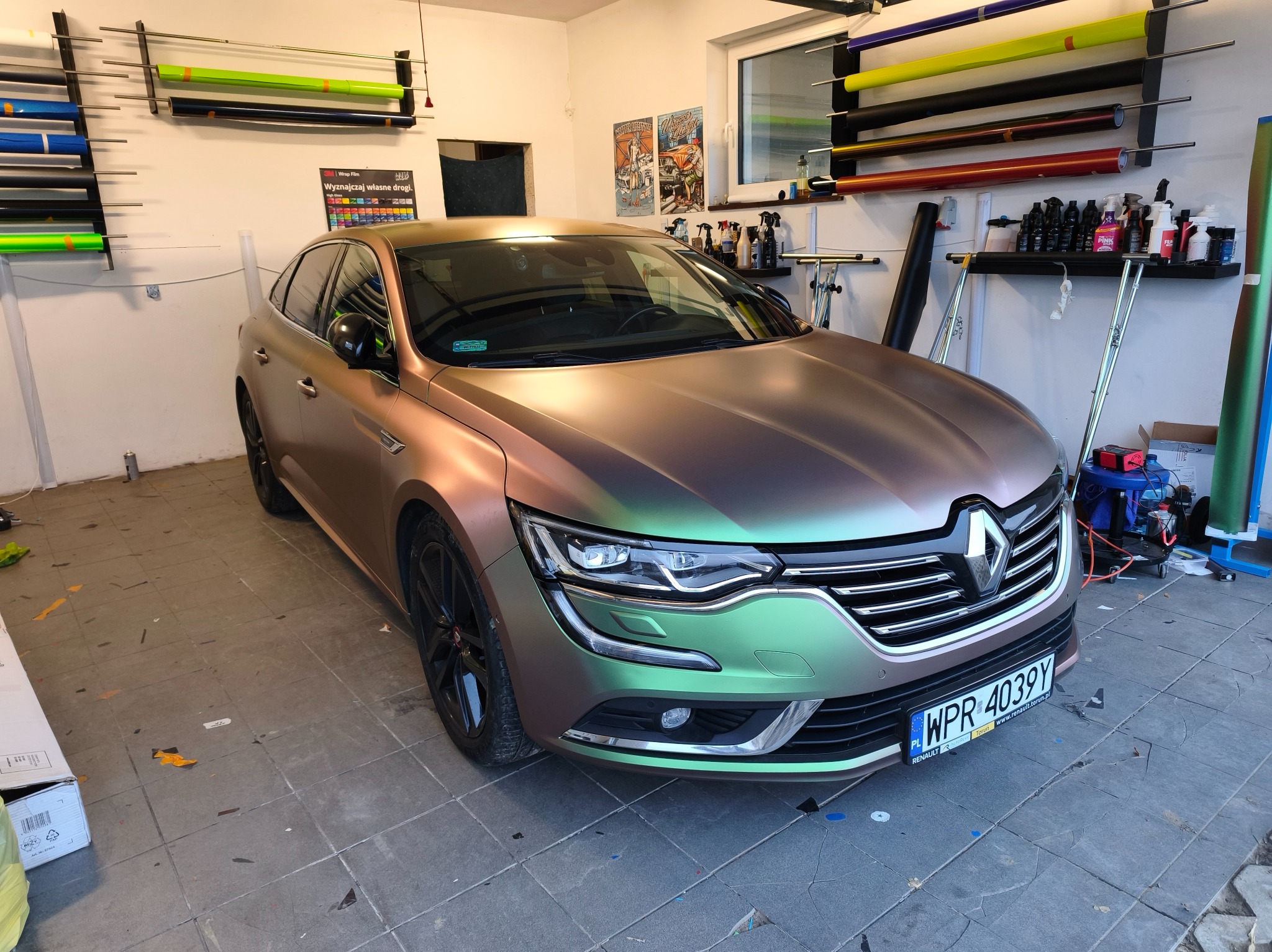 Renault Talisman po oklejeniu folią zmieniającą kolor, widoczne rolki folii na ścianie warsztatu, tablica rejestracyjna WPR 4039Y.