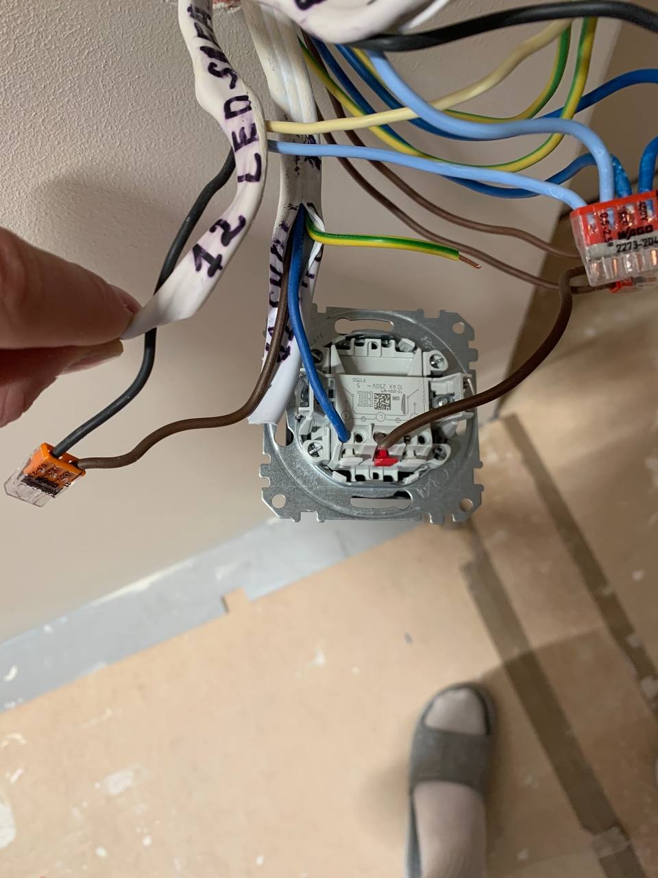 Podłączenie przewodów do gniazdka elektrycznego z użyciem złączek WAGO, widoczne oznaczenia przewodów taśmą z napisem 'LED S'