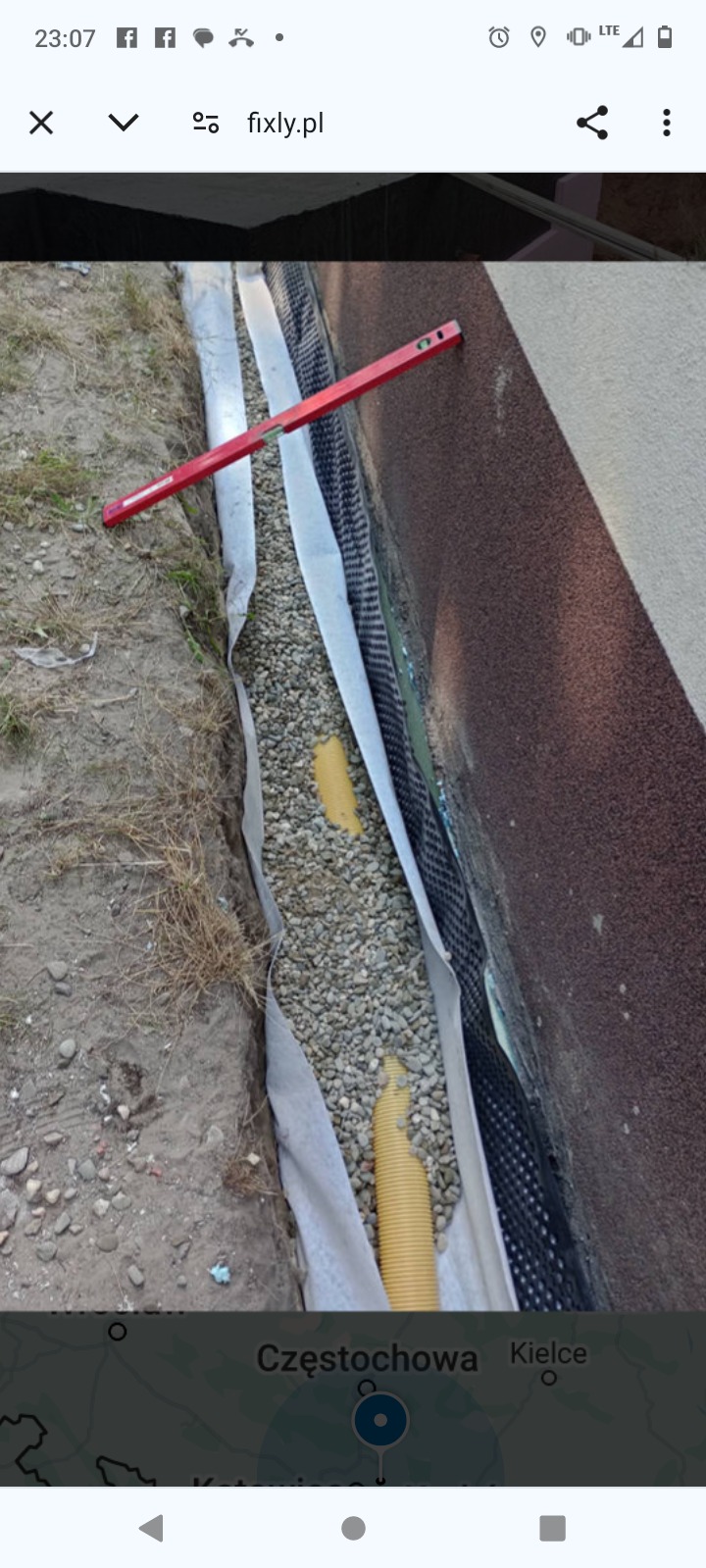 Fundament zabezpieczony folią kubełkową, geowłókniną i drenażem żwirowym; poziomica wskazuje wypoziomowanie.