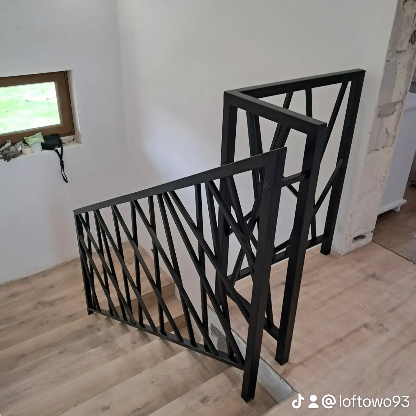 Nowoczesna balustrada metalowa w stylu loft, z geometrycznym wzorem, pomalowana na czarno. Realizacja z Olkusza. Widok z góry na schody.