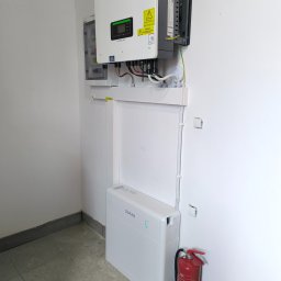 ECOAUTOMATION DAWID I WOJCIECH ZAHRT SPÓŁKA CYWILNA - Instalacja fotowoltaiczna marki Sofar w pomieszczeniu w Pile, widoczny inwerter, rozdzielnica oraz zasobnik energii, obok gaśnica.