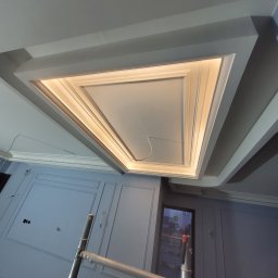 GWARANT - WOWA VOLODYMYR MELNYK - Sufit z dekoracyjną ramą i oświetleniem LED w trakcie prac wykończeniowych w Gdańsku, widoczna drabina malarska.