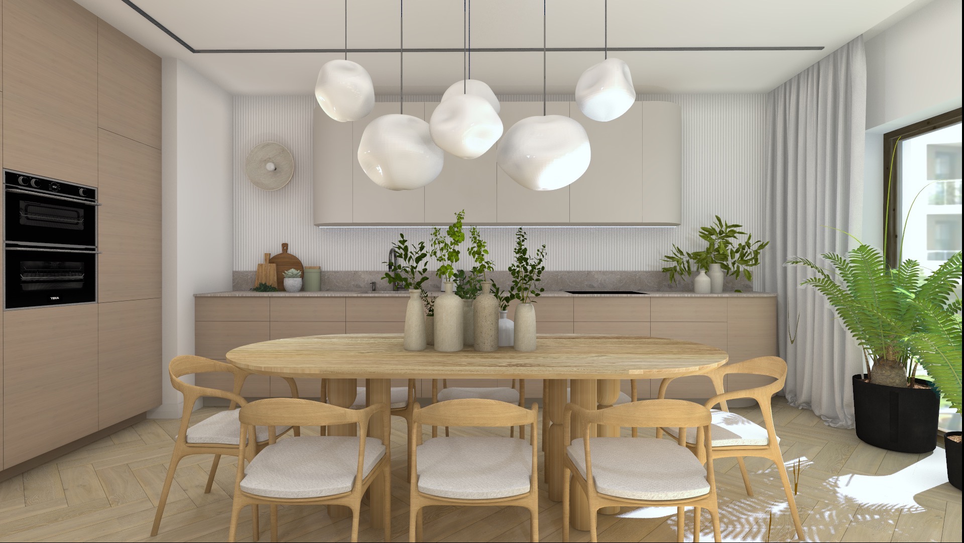 Jasna kuchnia z okrągłym drewnianym stołem i krzesłami, nad stołem zwisają designerskie lampy, na stole wazony z zielonymi roślinami, w tle zabudowa kuchenna w odcieniach beżu i duża paproć...