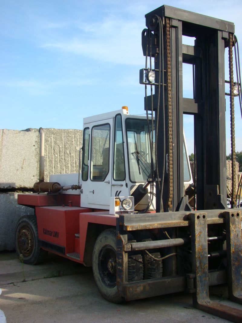 Wózek widłowy Kalmar LMV 12-1200 na tle jasnego nieba i stosu obrobionych bloków kamiennych.