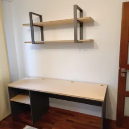 Nowoczesne biurko z jasnego drewna z czarnymi nogami i półką, wisząca półka z dwoma poziomami z drewnianymi blatami i metalową ramą, na tle białej ściany i drewnianej podłogi.