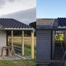 Atila dekarz - Montaż dachu z czarnej blachy falistej na drewnianej konstrukcji altany, widoczne elementy więźby i rynny, po lewej stronie drabina oparta o dach.