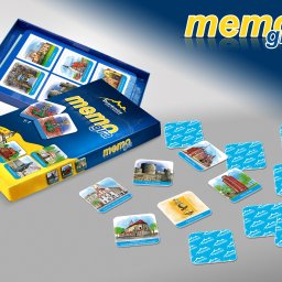 Michał Stawicki - Gra memory z ilustracjami zabytków Dzierżoniowa: pudełko, otwarte pudełko z kartami w środku i rozłożone karty z budynkami, wieżami i pomnikami.