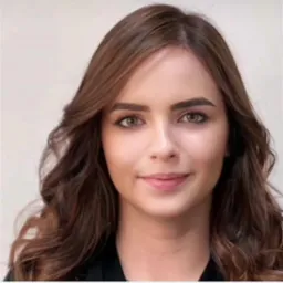 Portret uśmiechniętej kobiety z brązowymi, falowanymi włosami i zielonymi oczami na jasnym tle. Profesjonalny wizerunek, idealny do profilu zawodowego.