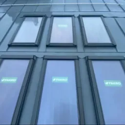 Metalowy dach z oknami dachowymi firmy Fakro, widok z dołu, szare wykończenie.