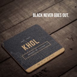 Touché Marketing - Stylowa, kwadratowa podkładka pod napoje z napisem 'KHOL' i hasłem 'Black never goes out', leżąca na drewnianym stole. Minimalistyczny design w ciemnej tonacji.