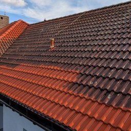 Sebo Dach I Bruk jak nowy - Częściowo wyczyszczony dach z czerwonej dachówki, widoczna różnica między czystą a zabrudzoną powierzchnią, komin w tle.