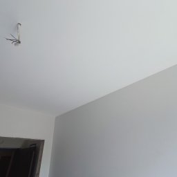 MATS-BUD - Świeżo pomalowane wnętrze z wystającymi przewodami elektrycznymi z sufitu, widoczne ościeże drzwi